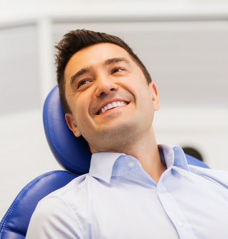 Man leaning back in dental chair smiling