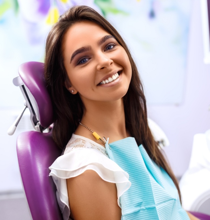 Smiling young woman sitting in dental chair