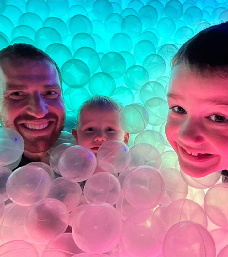 Doctor Proulx with his two sons in a ball pit
