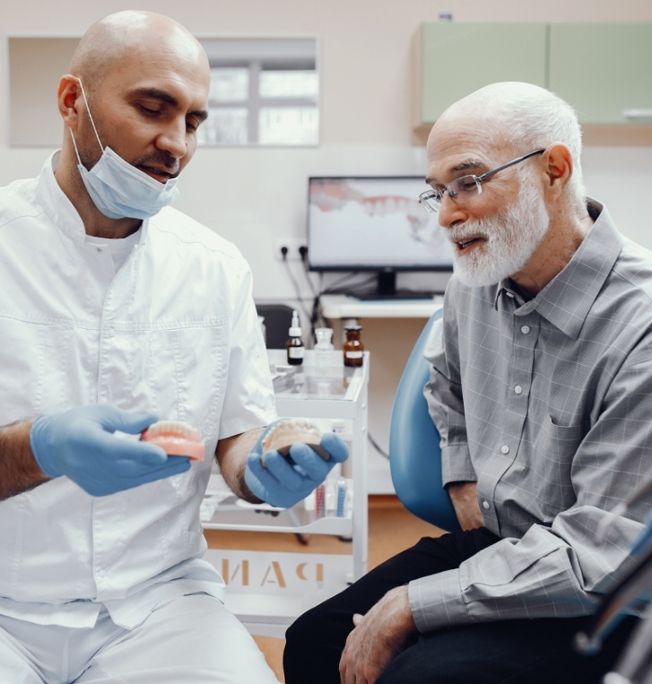 Dentist showing All on 4 dental implants to a senior patient