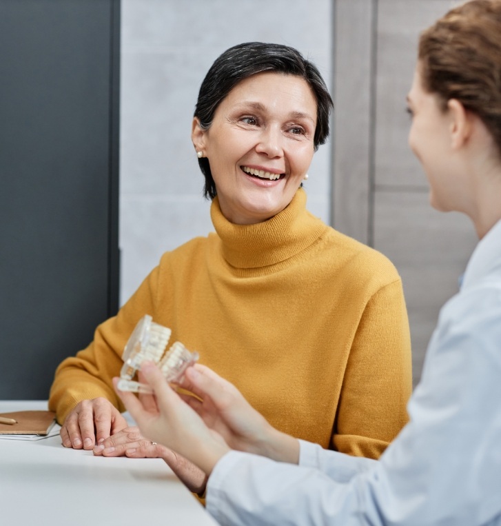 Woman in yellow sweater talking to her dentist