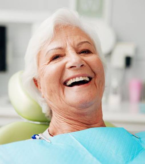 Happy senior patient in dental treatment chair
