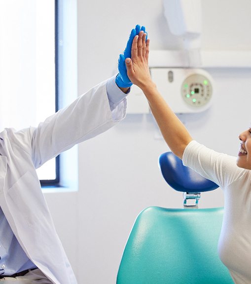 Dentist and patient high-fiving each other