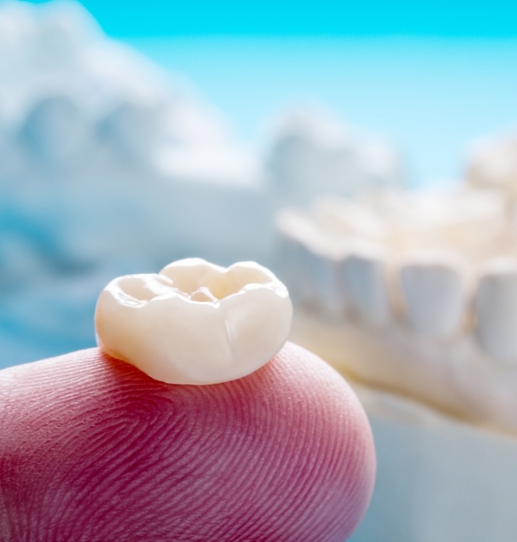 Dental crown resting on a finger