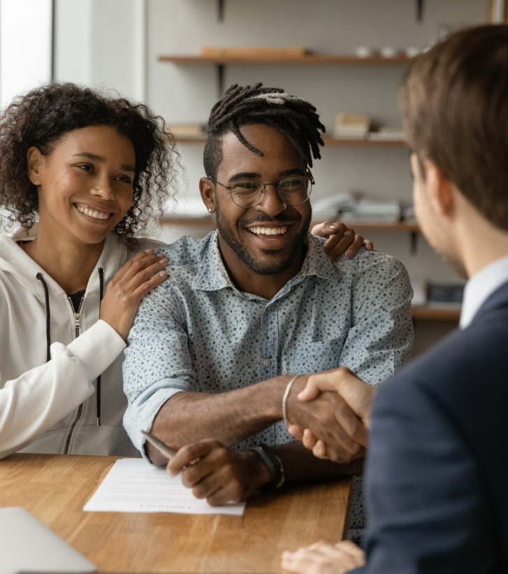 Man shaking hands with person across desk