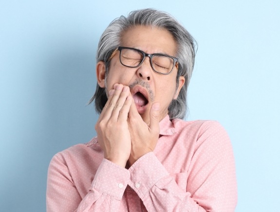Man holding his cheek in pain with both hands