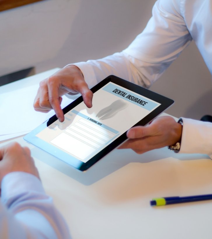 Two people looking at dental insurance information on tablet