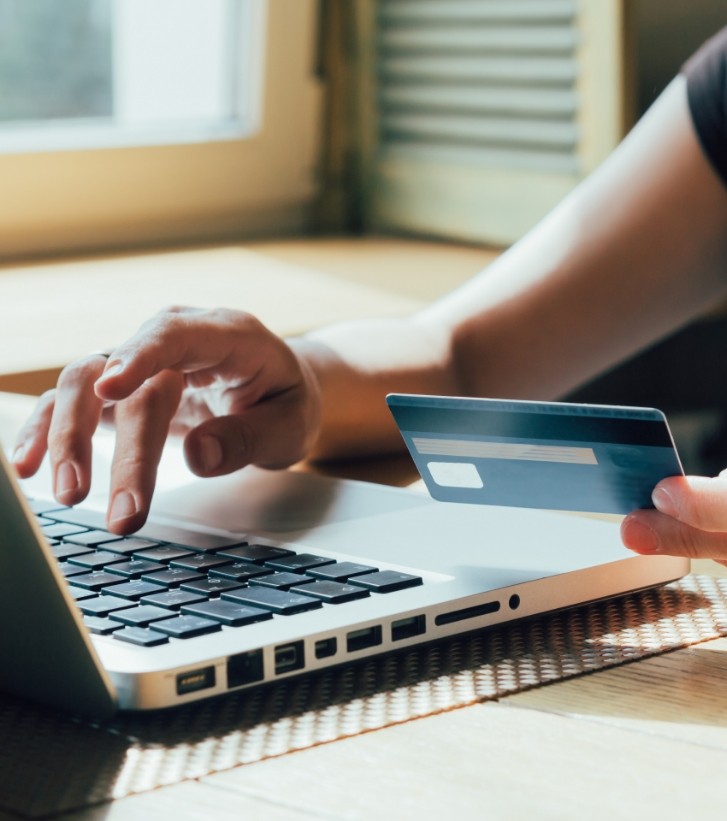 Person entering their credit card information into a laptop