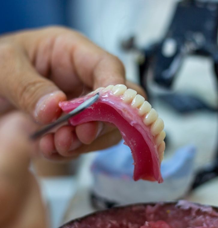 Hands crafting a denture