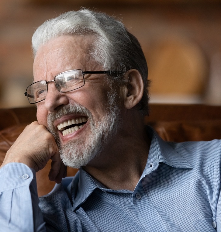 Smiling older man resting his chin in his hand