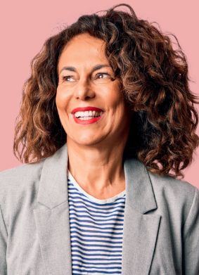 Woman in gray blazer smiling and looking off into the distance