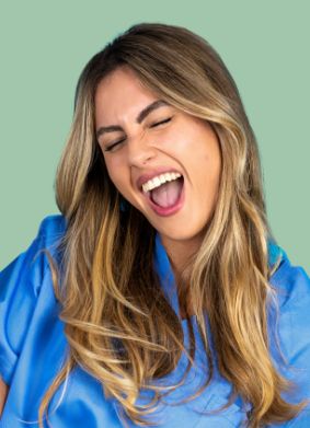 Woman in blue blouse grinning with eyes closed