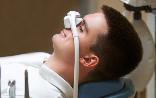 Patient relaxing while breathing in nitrous oxide in treatment chair