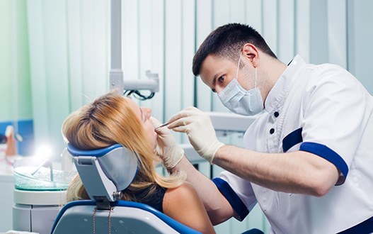 A young dentist working with a female patient