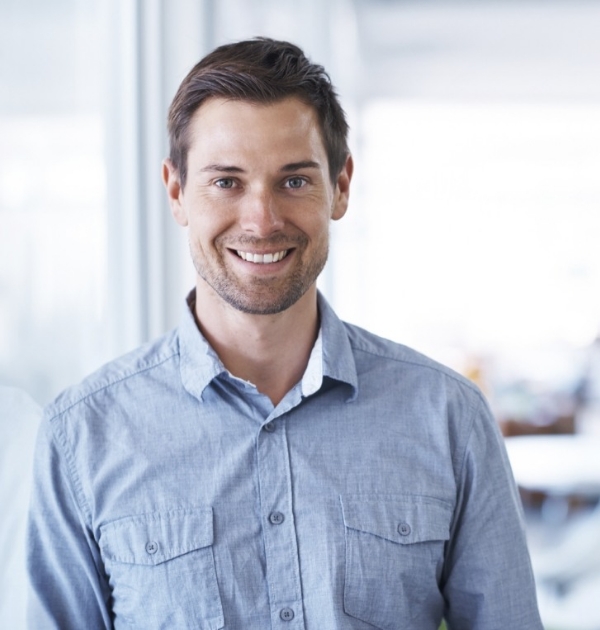 Man in denim shirt smiling after preventive dentistry in Hillsboro