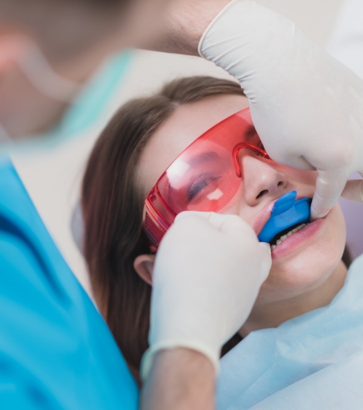 Young girl getting fluoride treatment in dental chair