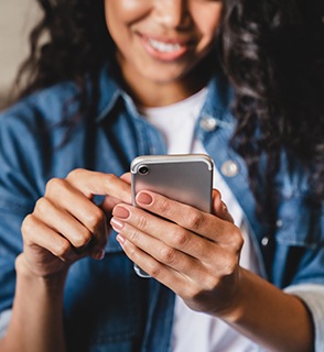 Smiling woman scrolling on her phone