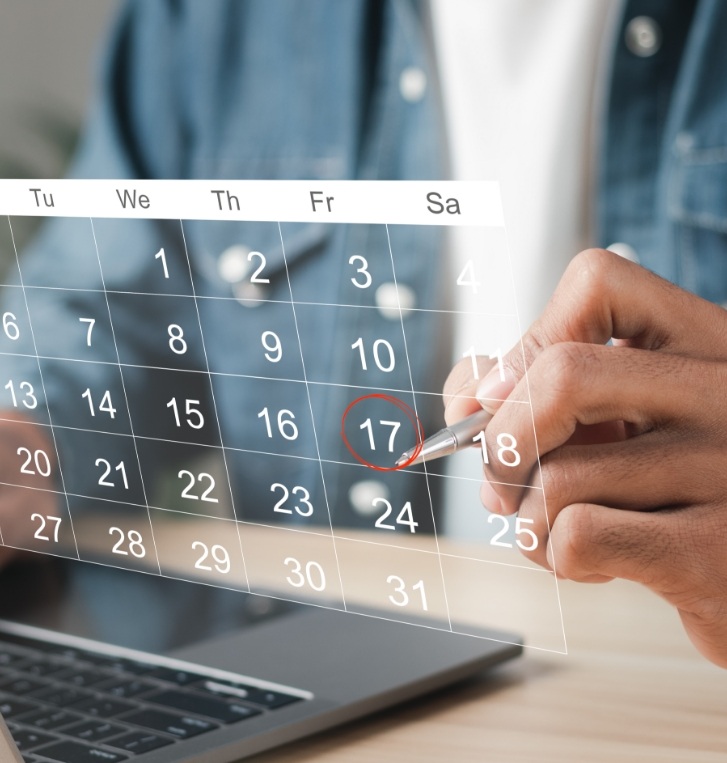 Person circling date of dental appointment on calendar