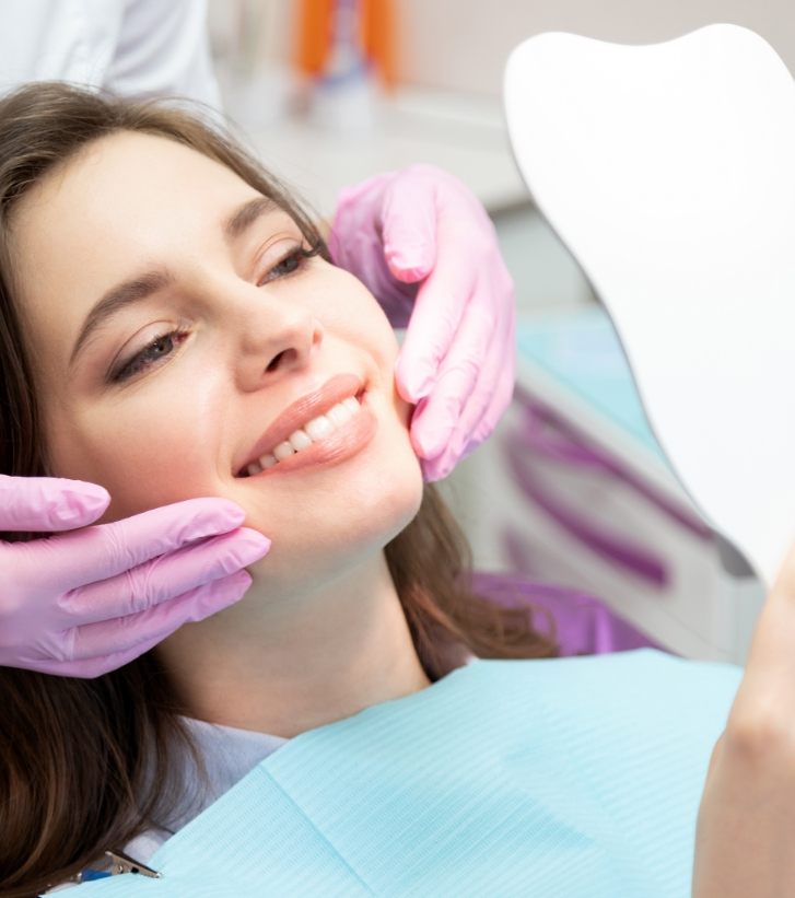 Dental patient admiring her smile after full mouth reconstruction in Hillsboro