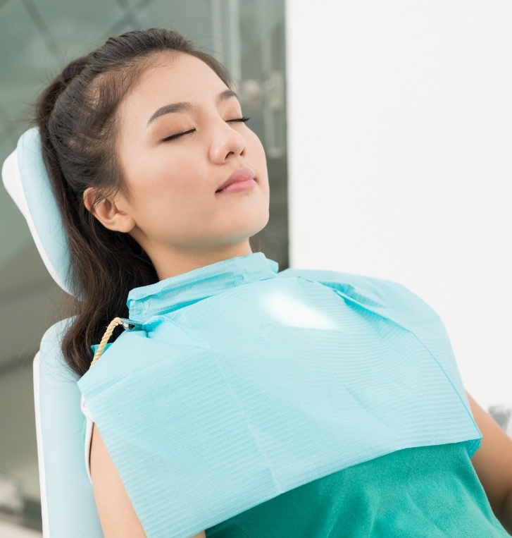 Woman relaxing in dental chair thanks to sedation dentistry in Hillsboro