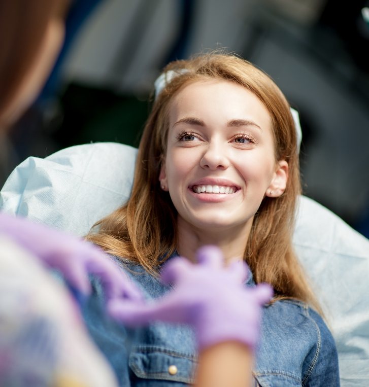 Woman in dental chair talking to her dentist