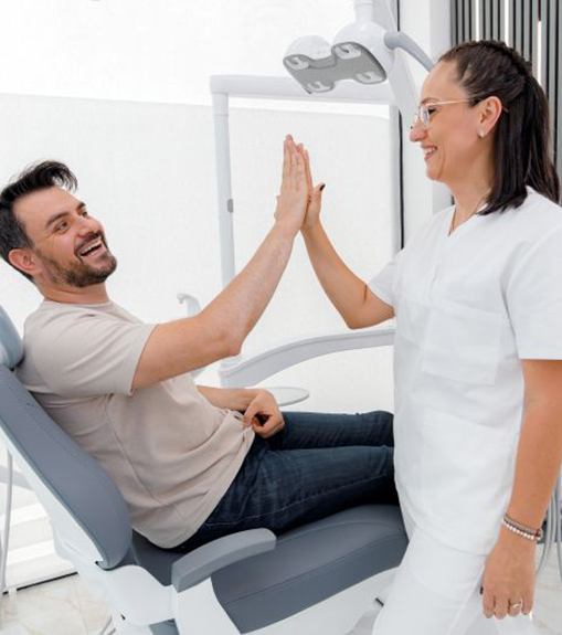 Patient high-fiving dental team member