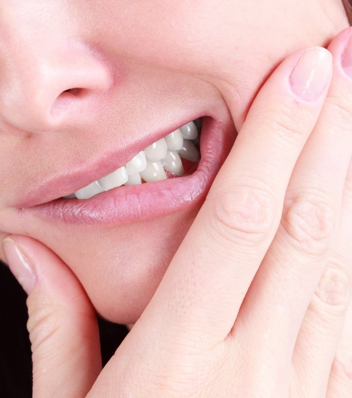 Close up of person holding one cheek in pain