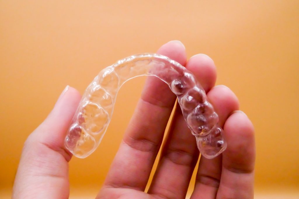 Closeup of patient holding Invisalign aligner