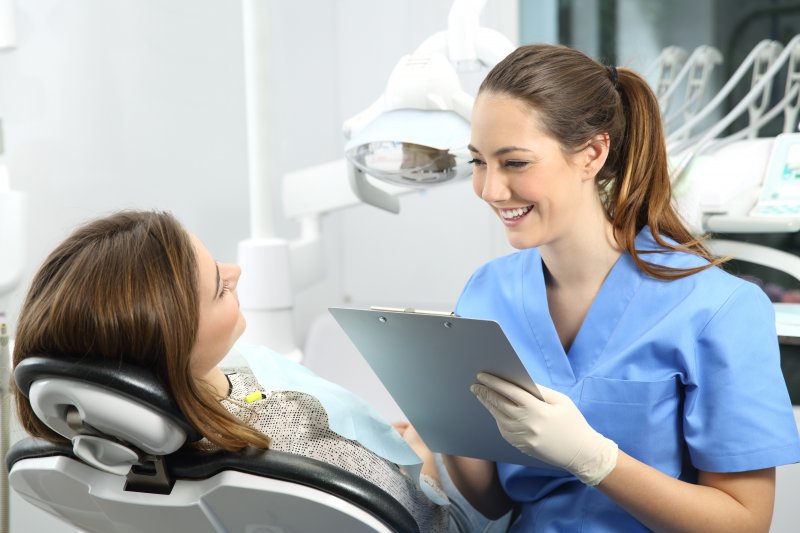 dentist answering questions about lifespan of dental implants 