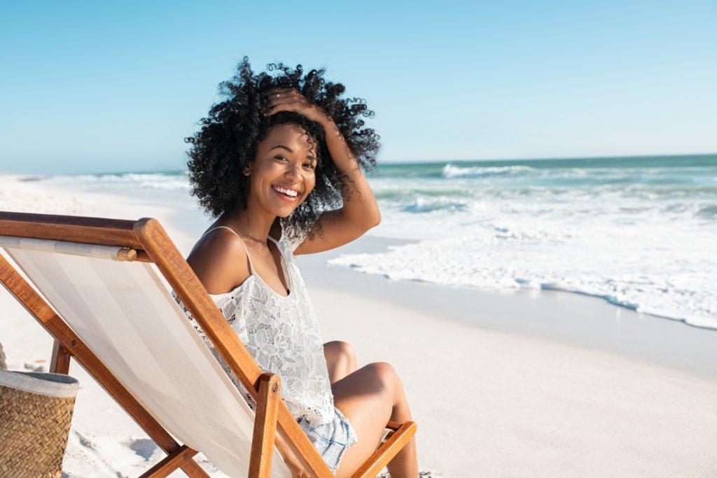 Woman smiling while relaxing on beach