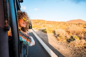 Woman leaning out the window of a car.