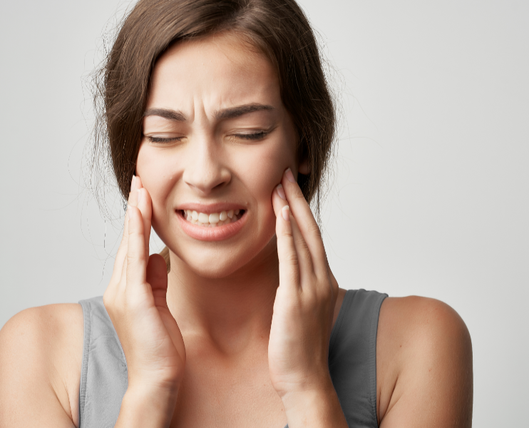 Woman holding jaw in pain
